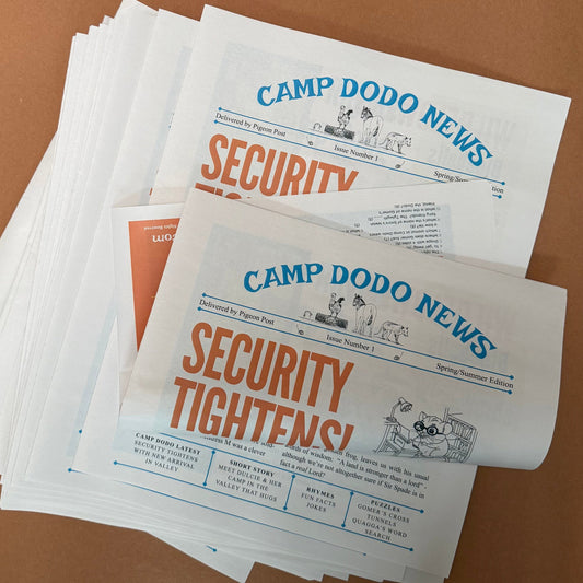 Stack of 'Camp Dodo News' newpapers on a brown background