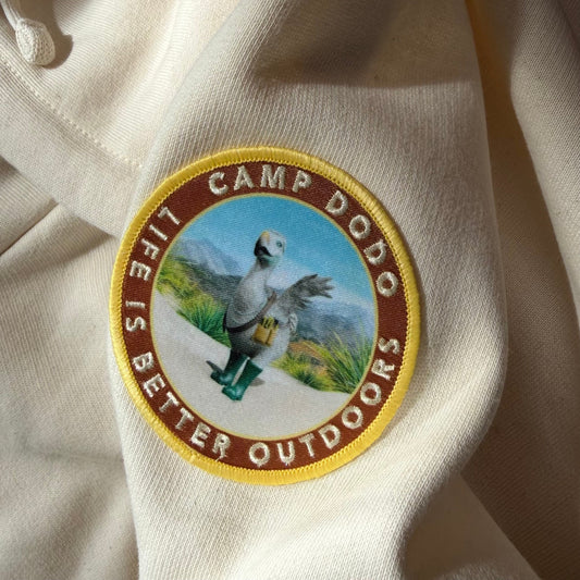 Camp Dodo Iron-on Patch on a cream hoodie with 'Camp Dodo' and 'Life is Better Outdoors' text