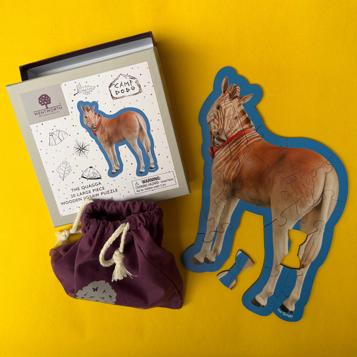 Wooden puzzle of a Quagga with packaging and drawstring bag on a yellow background